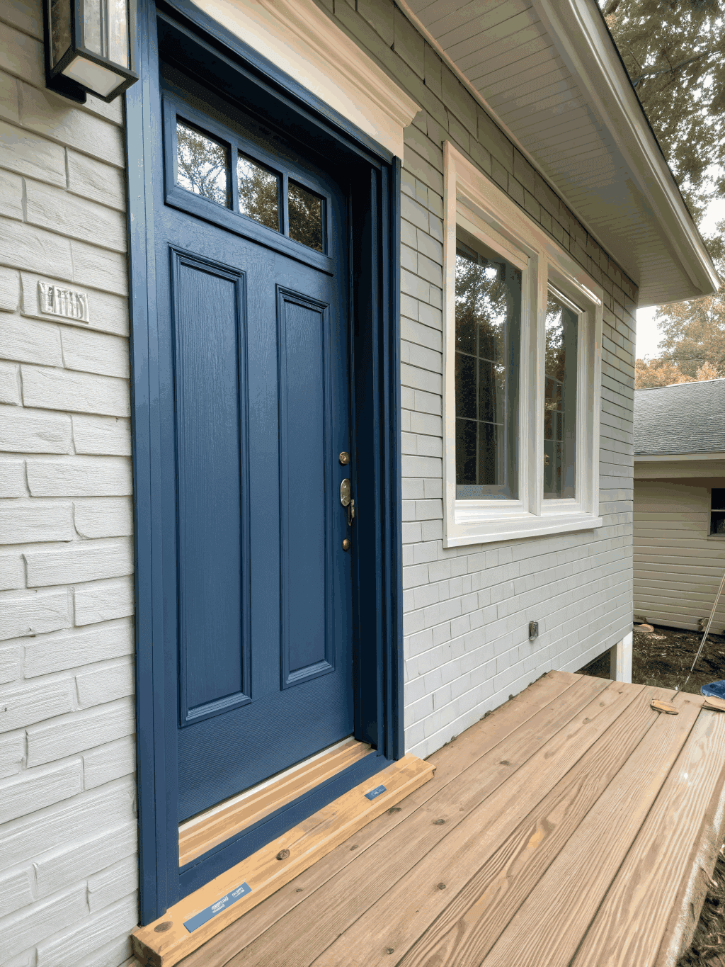 Classic wooden front door painted in satin navy blue